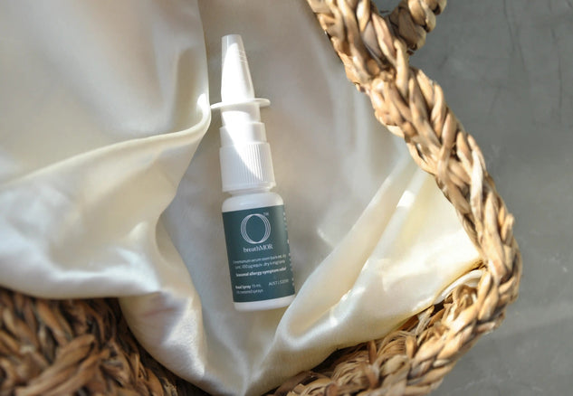 Skincare product with a dropper bottle in a woven basket on a neutral background