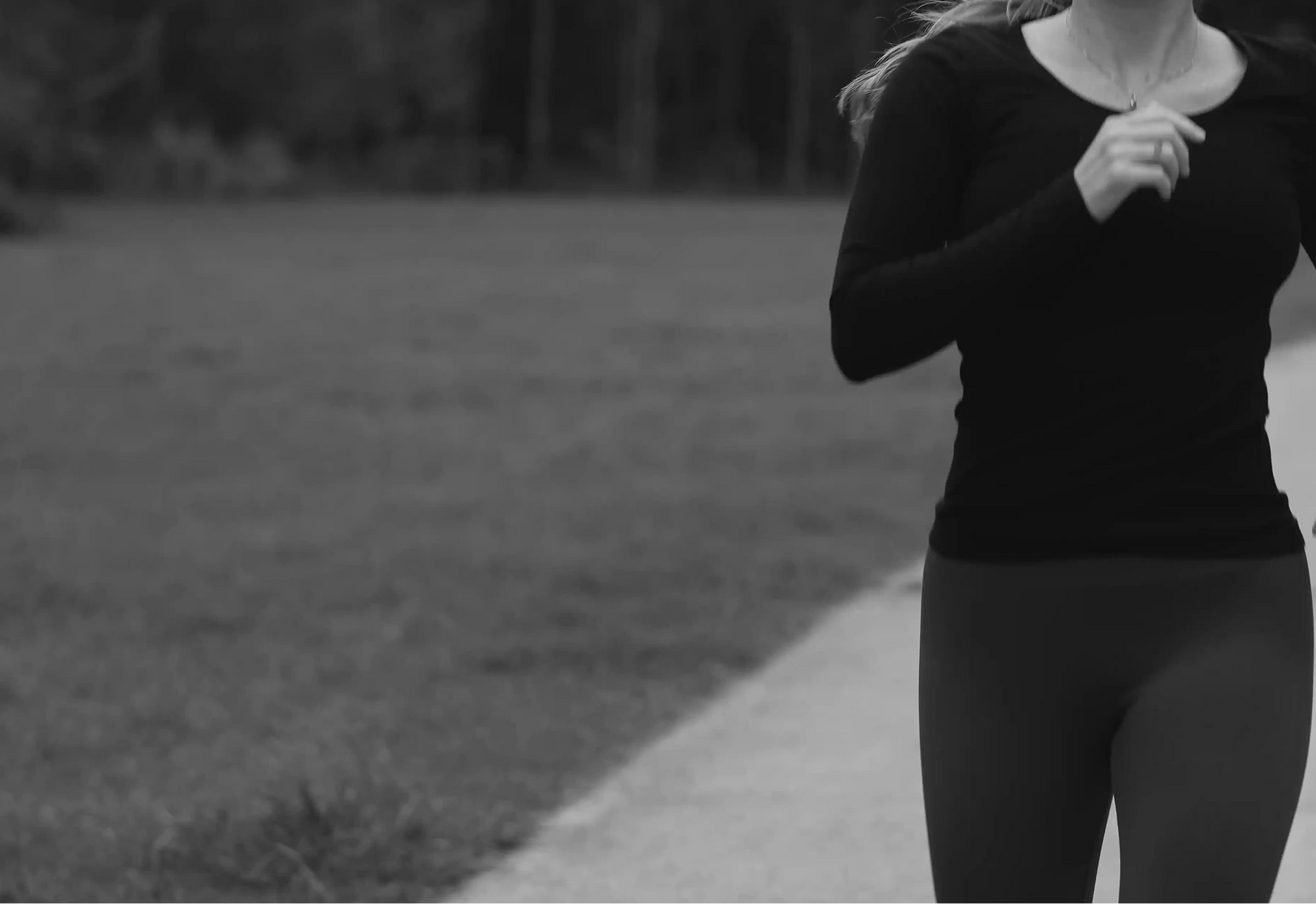 Person running on a path with grass and trees in the background